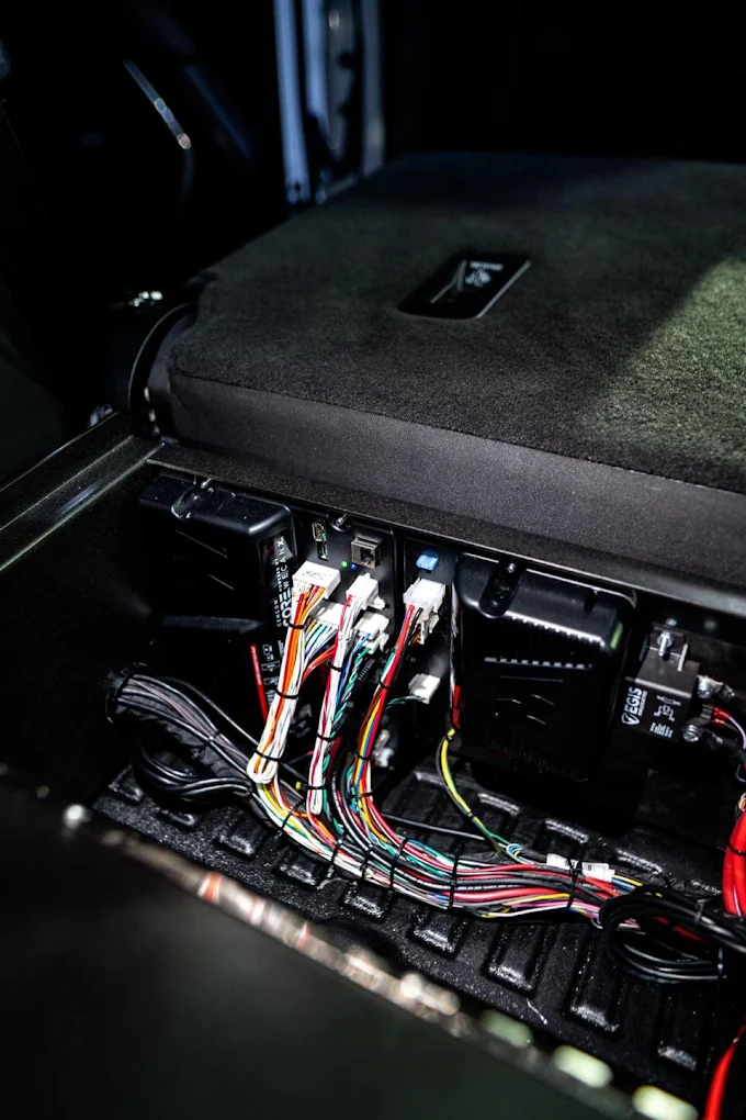 Installation de faisceau électrique et relais sous la banquette d'un véhicule